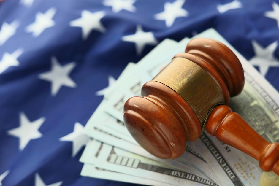 Close-up of a gavel on US dollar bills with American flag backdrop symbolizing justice and finance.